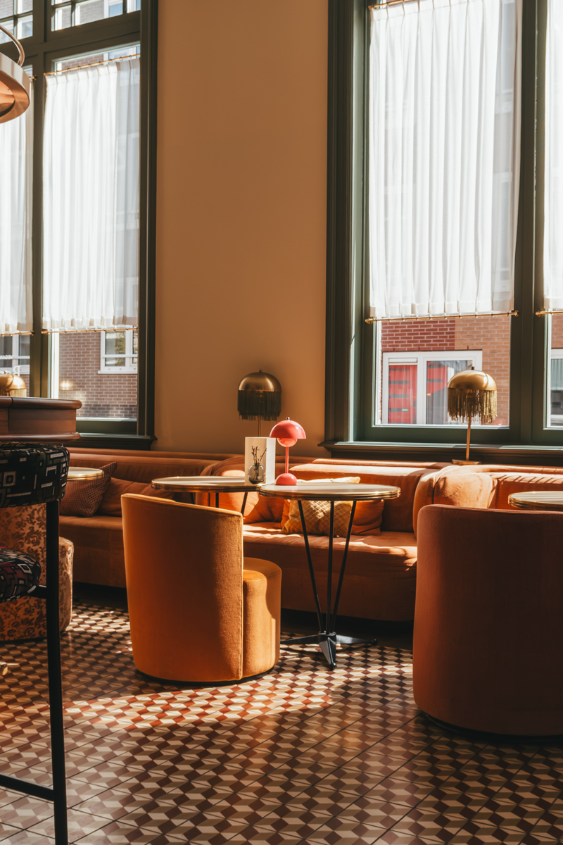 Warm amber lounge with cognac leather seating at Hotel Mercier, Amsterdam