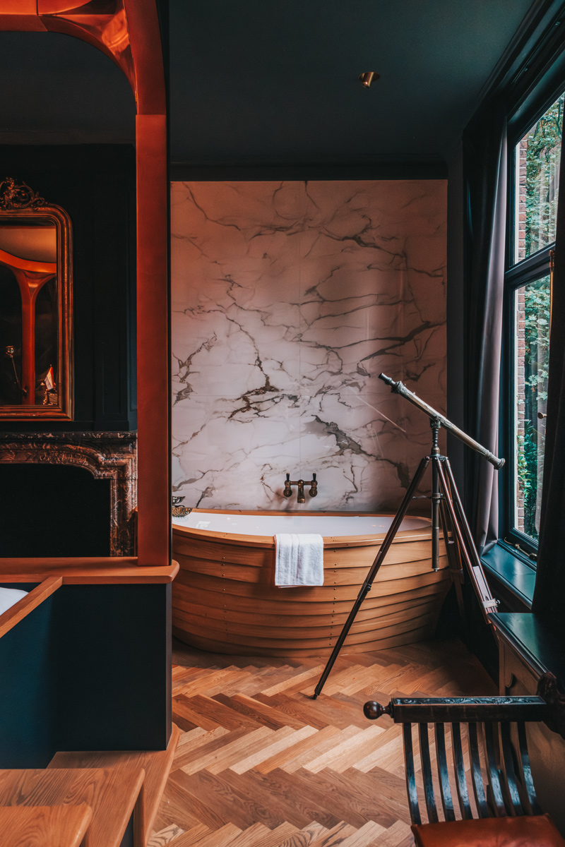 Marble-walled bath with herringbone floors at Hotel The Noblemen, Amsterdam