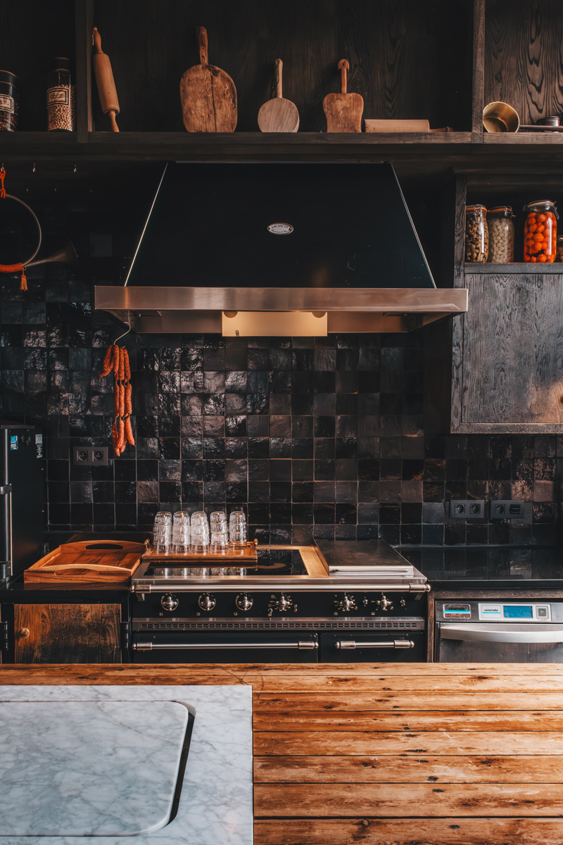 Dark-tiled professional kitchen at 1898 The Post, Ghent